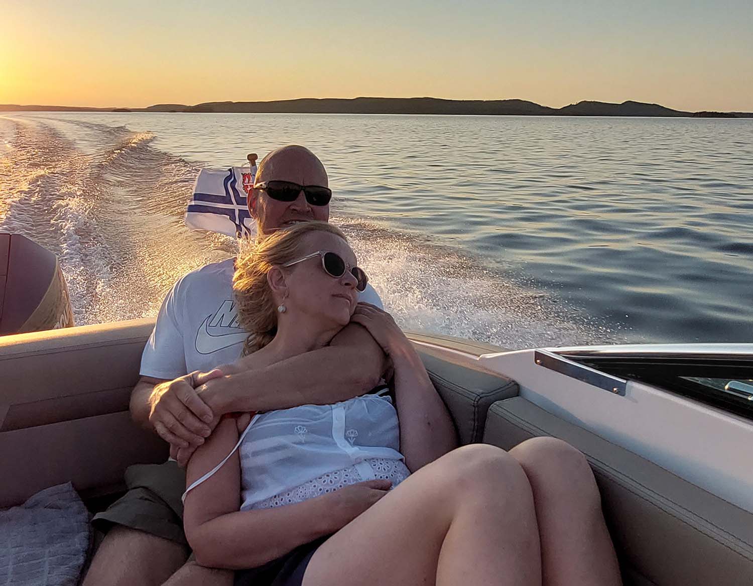 Pariskunta katsomassa auringonlaskua veneen kyydissä Päijänteellä