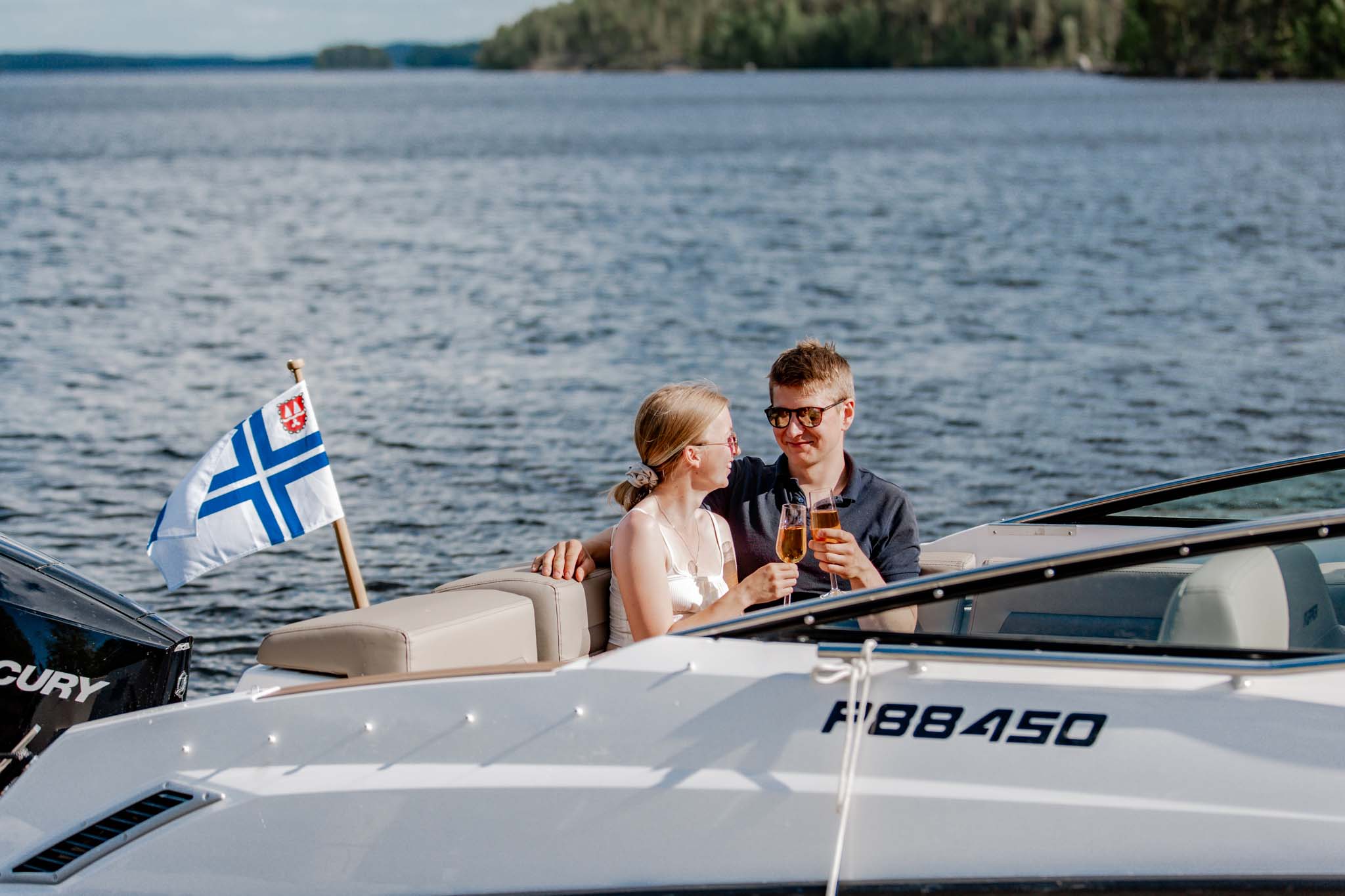Pariskunta nauttimassa kuohuviiniä veneessä Päijänteellä